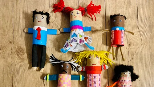 Colorful handmade dolls on wooden surface.