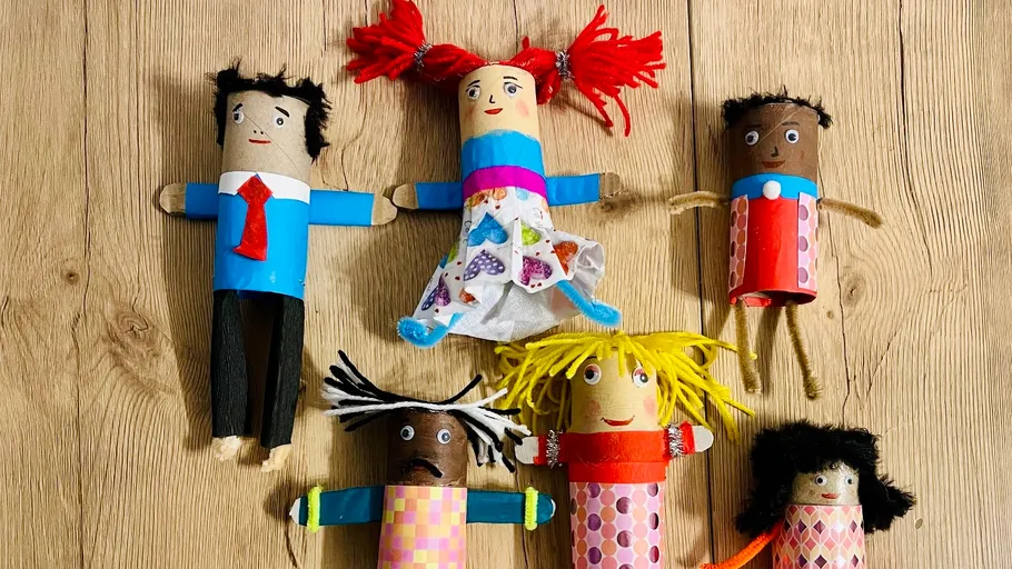 Colorful handmade dolls on wooden surface.