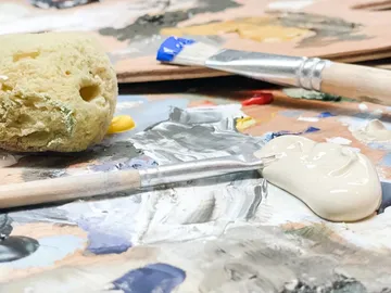 Brush and sponge lie on a color palette.