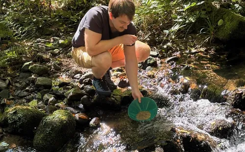 Man panning for gold in a stream.