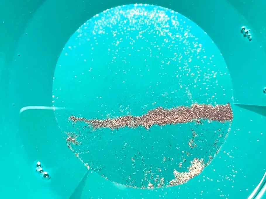 Gold flakes in a blue pan.