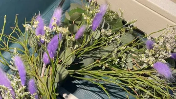 Lila und weiße Blumen auf Holzoberfläche.