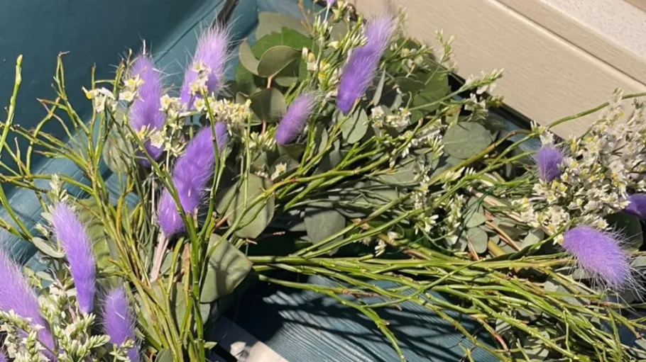 Lila und weiße Blumen auf Holzoberfläche.