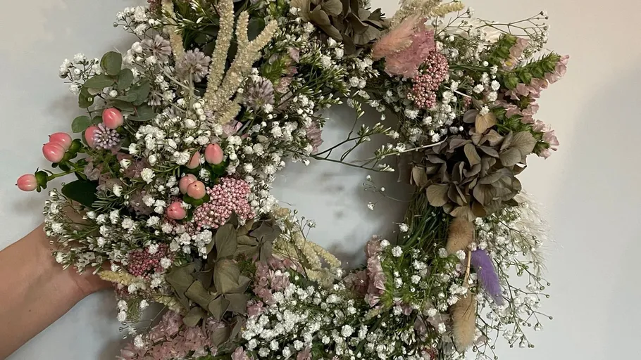 Floral wreath held against a white background.