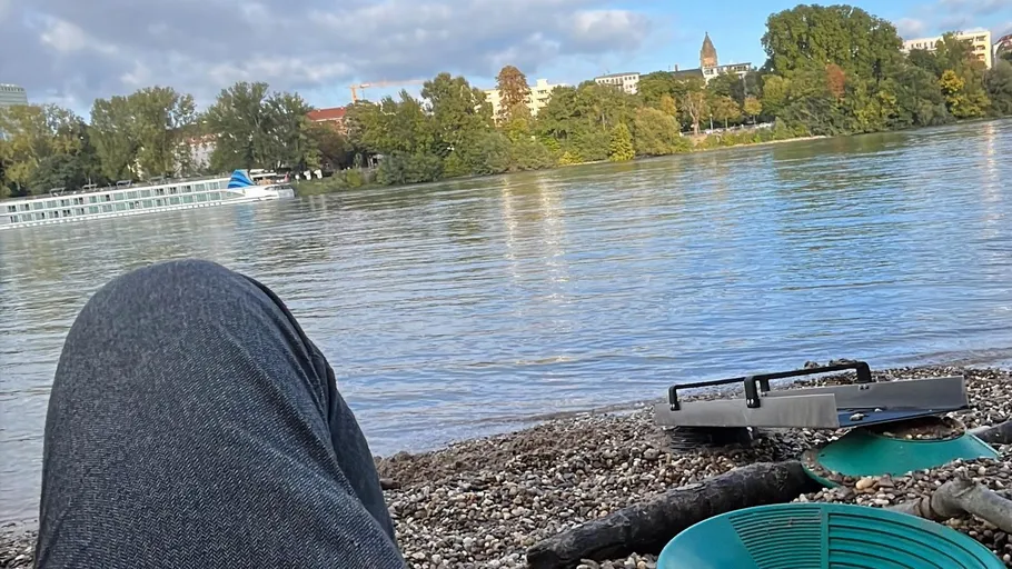 Flussuferansicht mit Stadt, Pfannen und Person.