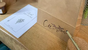 Paper bag with floral design on table.