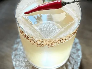 A drink with a red chilli and ice cubes.