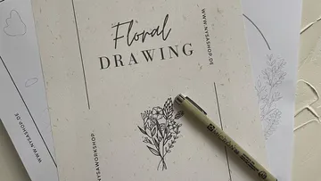 Floral drawing guide with pen on paper.