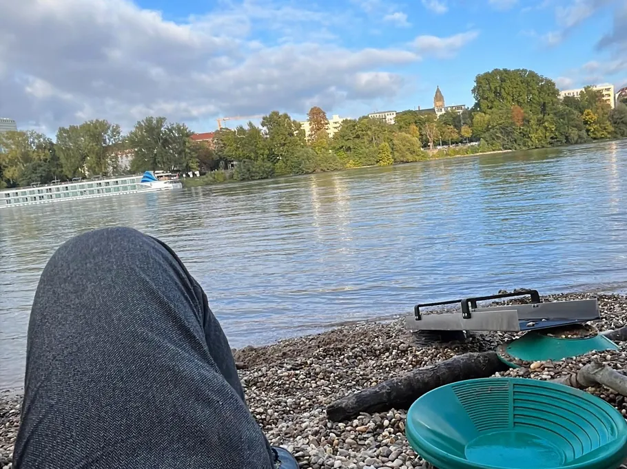 Person entspannt am Fluss mit Boot in der Nähe.