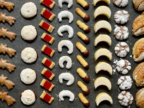 Colourful cookies in several rows on a dark background.