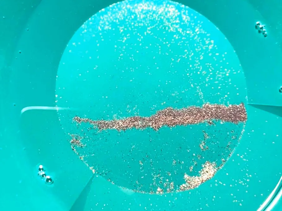 Gold dust in green pan under sunlight.