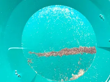 Goldstaub in einem blauen Waschpfanne.