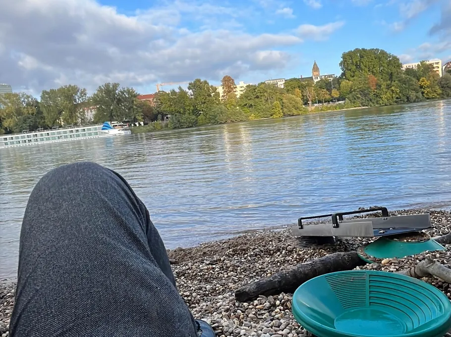 Person entspannt sich an einem Fluss mit Booten.