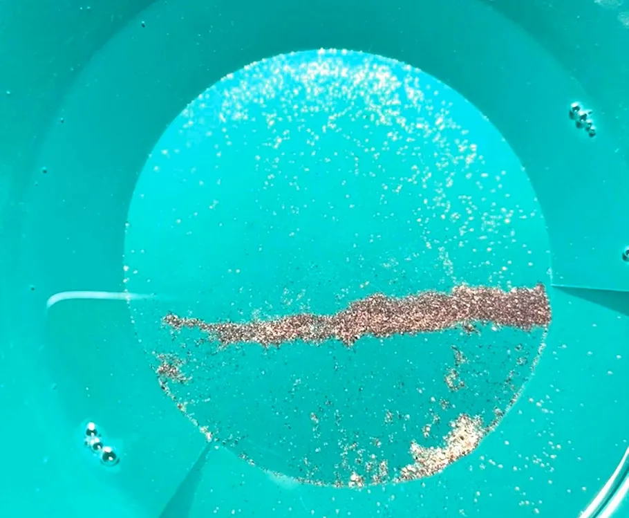 Goldflocken in einer türkisfarbenen Pfanne.