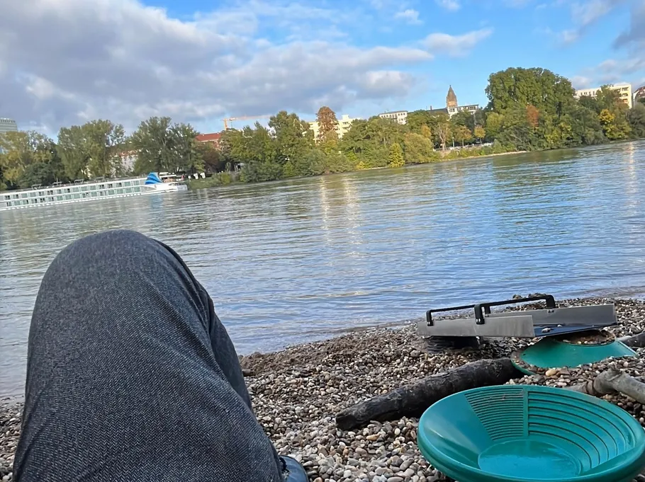 Person entspannt am Kiesstrand am Fluss.