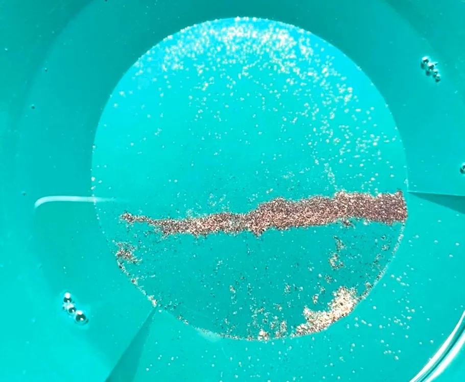 Gold flakes in a blue pan.