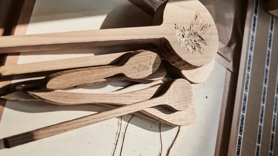 Wooden spoons on a table in sunlight.