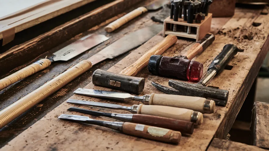 Carpentry tools neatly arranged on wooden workbench.