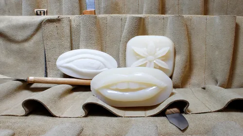Soap carvings displayed on a fabric background.