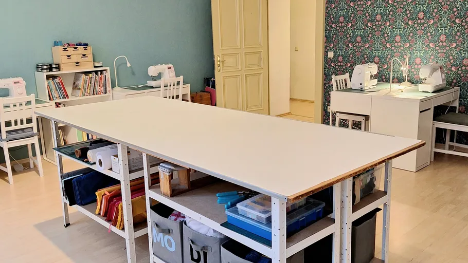 Nähzimmer mit Tischen und Maschinen, bunte Wände.