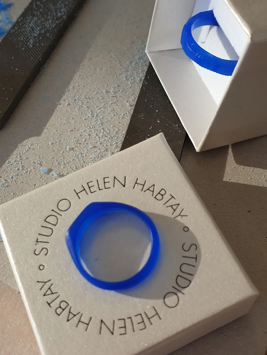 Blue resin ring on textured surface.