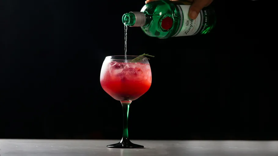Gin poured into red cocktail glass.