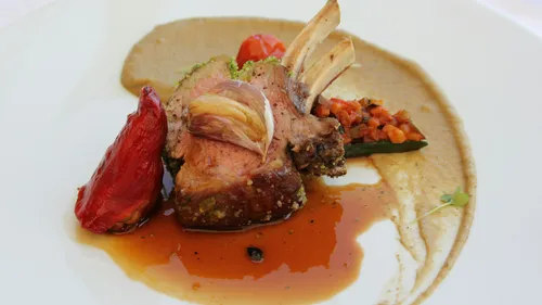 Gourmet-Lammkarree mit Sauce und Gemüse.