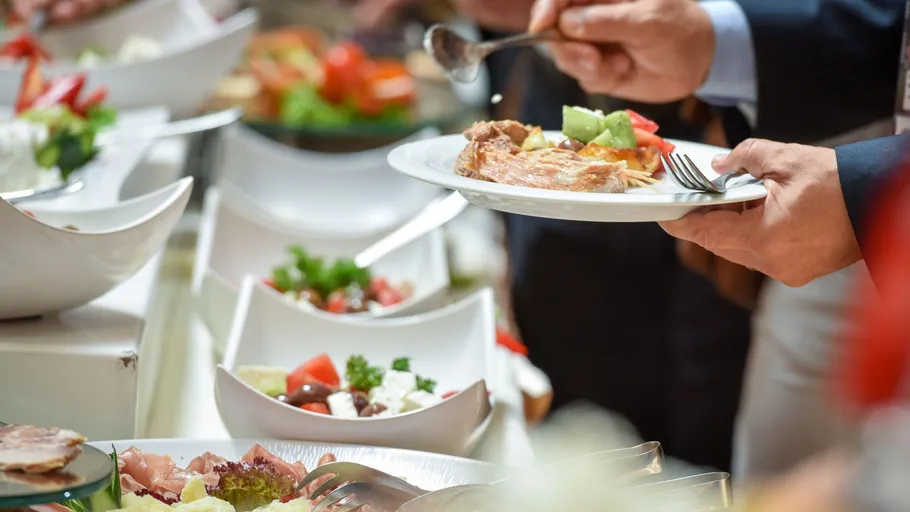 Menschen bedienen sich am Buffet-Tisch.