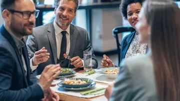 Group of people eating and talking in restaurant.