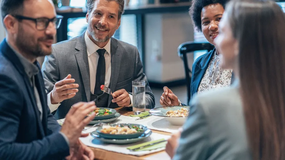 Gruppe von Menschen isst und spricht im Restaurant.