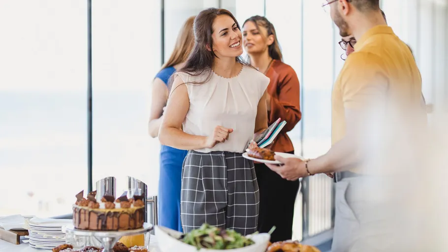 Menschen unterhalten sich bei einem Buffet.