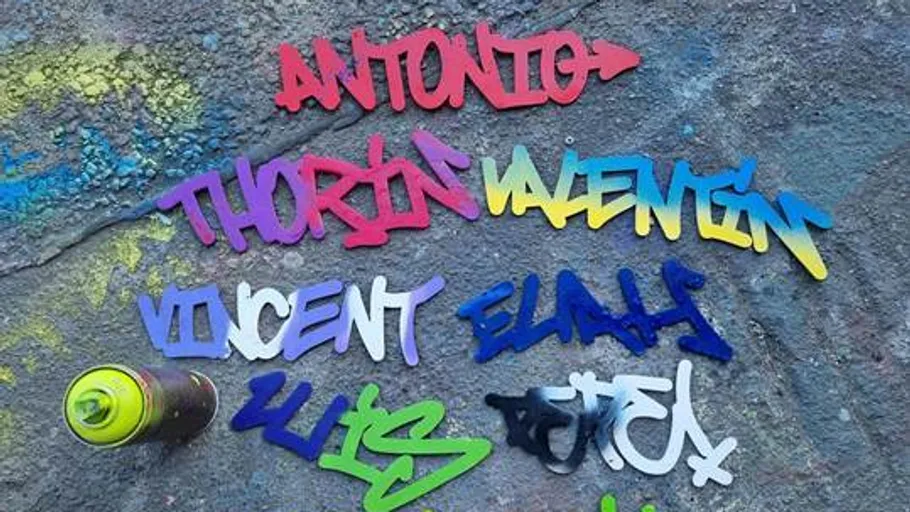 Spray-painted names on textured wall surface.