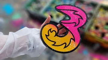 Hand hält bunte abstrakte Form im Freien.