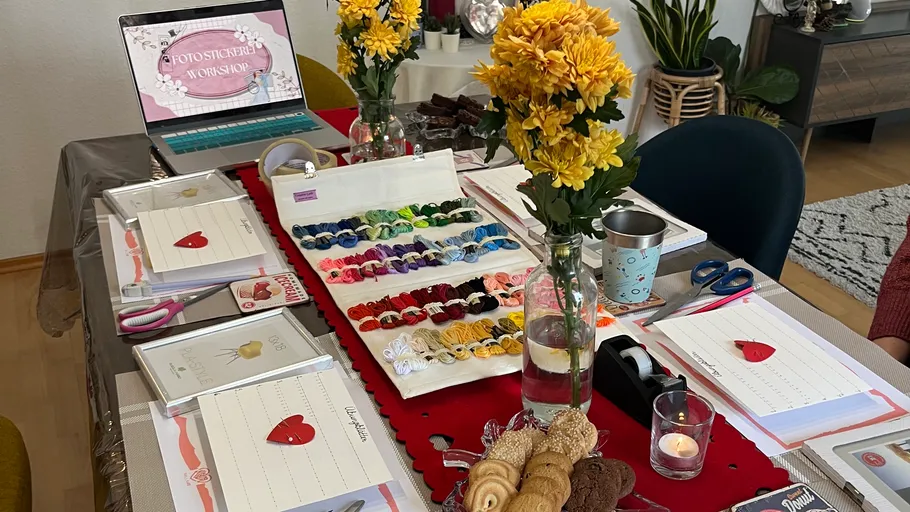 Bunter Workshop-Tisch mit Blumen und Materialien.