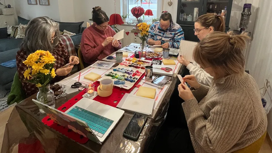 Five women crafting around a decorated table.