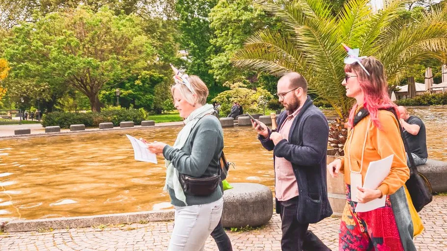 People walking in park, holding papers.