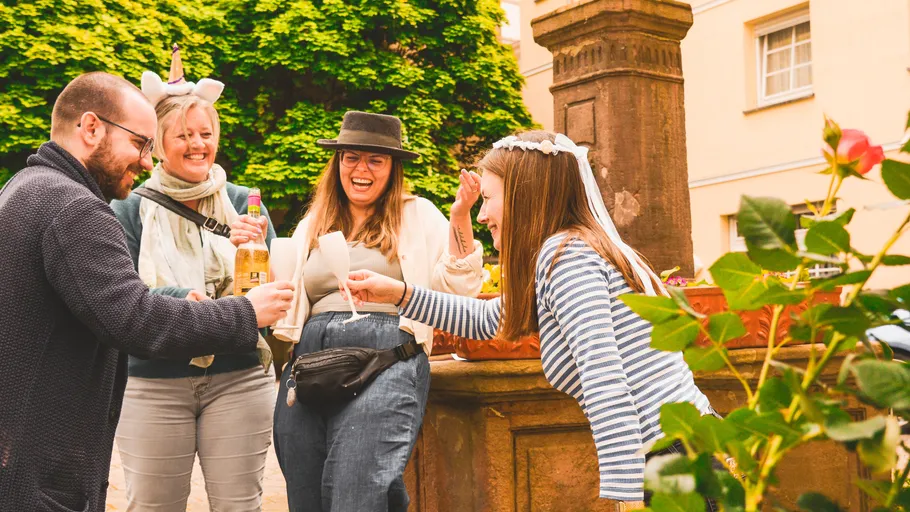 Group of friends laughing and toasting outside.
