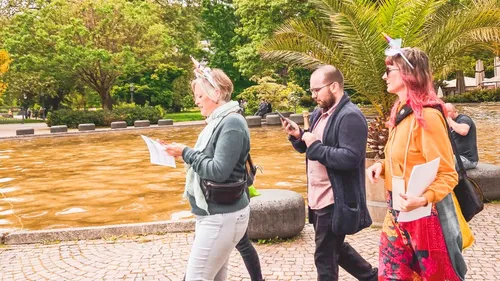 Group walking by the water with papers.