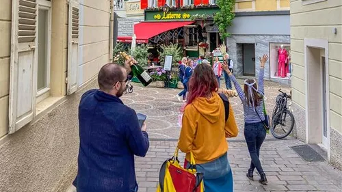People walking towards restaurant in city street.