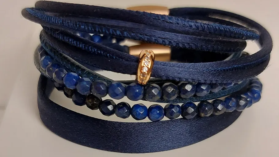 Blue layered bracelet with gold accents, close-up.
