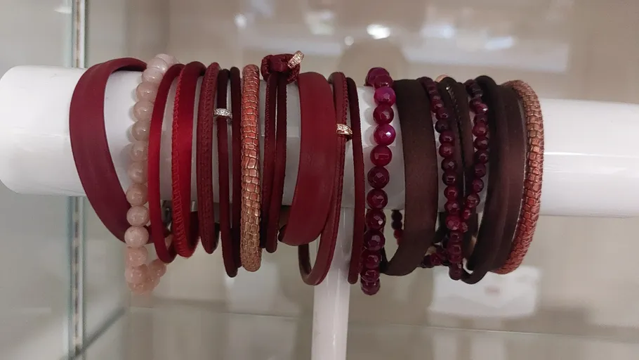 Verschiedene Armbänder auf einem weißen Ständer arrangiert.