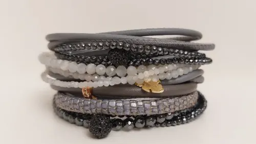 Stapel aus grauen und schwarzen Perlenarmbändern.