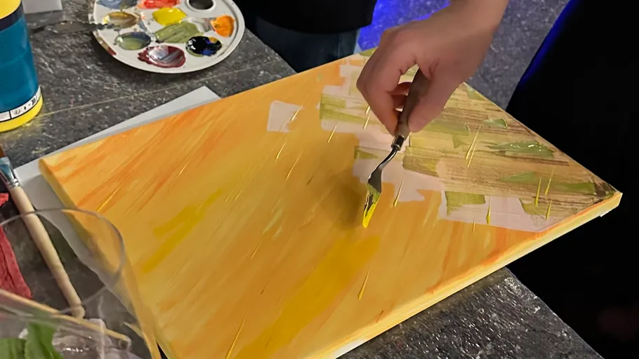 Hand painting on yellow canvas with palette knife.