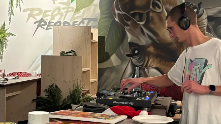 DJ mixt Musik in dekoriertem Raum.