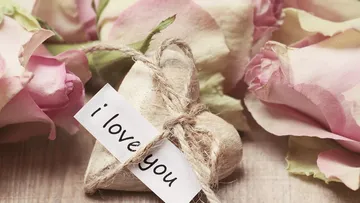 Holzherz mit Rosen und 'Ich liebe dich' Notiz.
