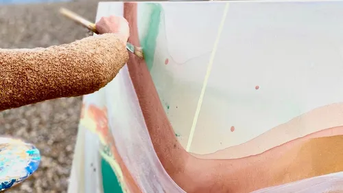 Person malt abstrakte Kunst im Freien.