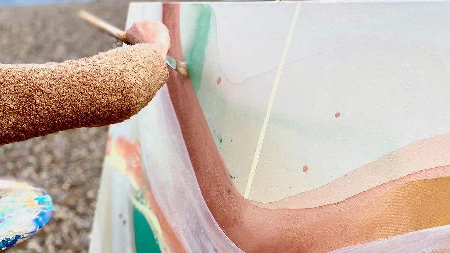 Person painting abstract art outdoors.