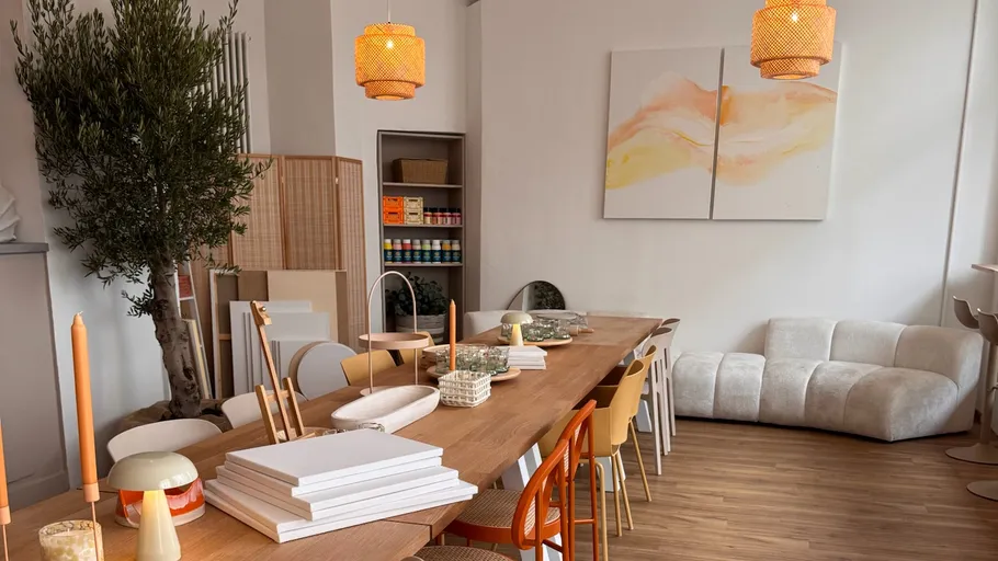 Gemütliches Studio mit langem Tisch und Kunstmaterialien.