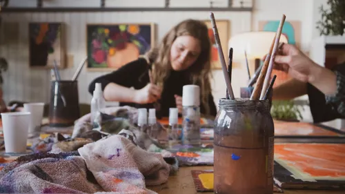 Malerin arbeitet in einem bunten Atelier.