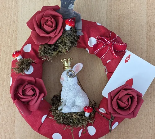 Decorative wreath with rabbit, mushrooms, and card.